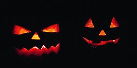 Foto: Zwei orangerot in Schwarz leuchtende Kuerbisfratzen
