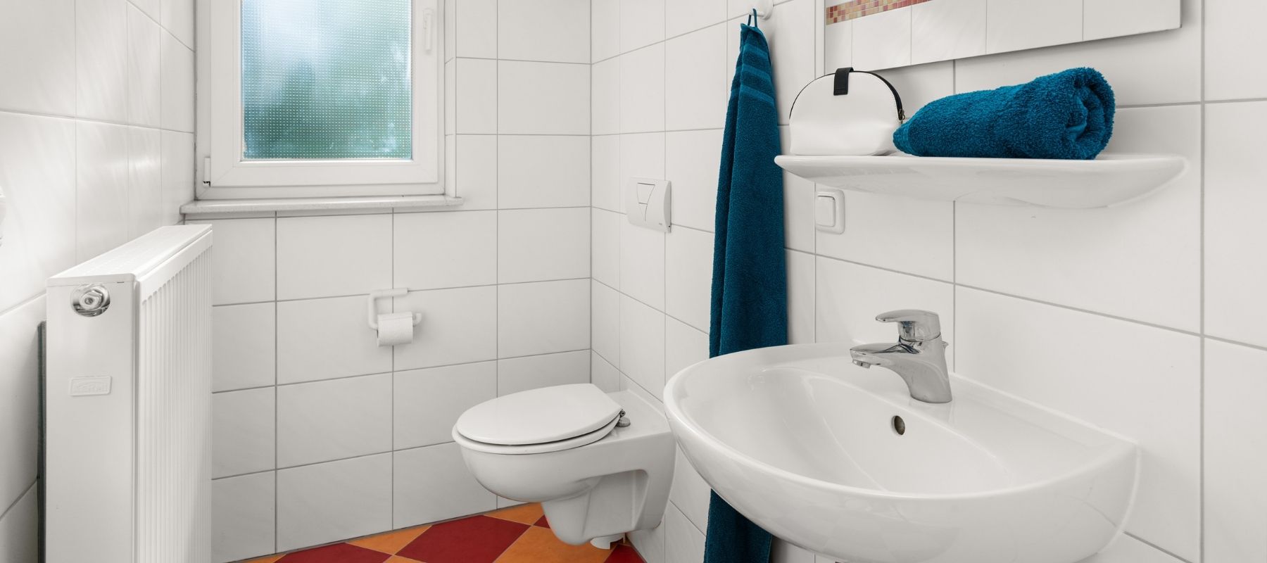 Foto vom Bad eines Einzelapartments in einer WG. Zu sehen sind Waschbecken, Toilette und Fenster.
