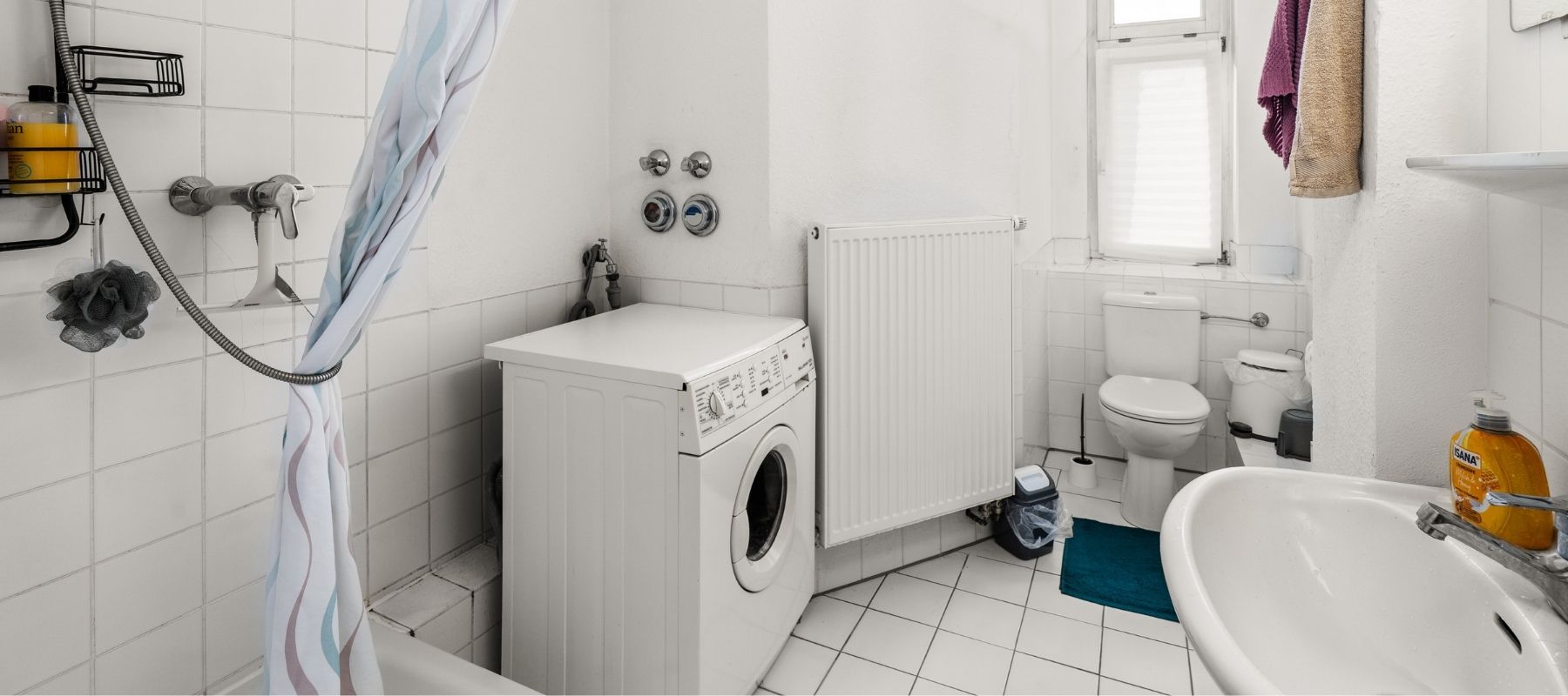 WG-Bad in der Hegelsbergstraße 20. Zu sehen sind Toilette, Dusche, Waschbecken sowie eine Waschmaschine.