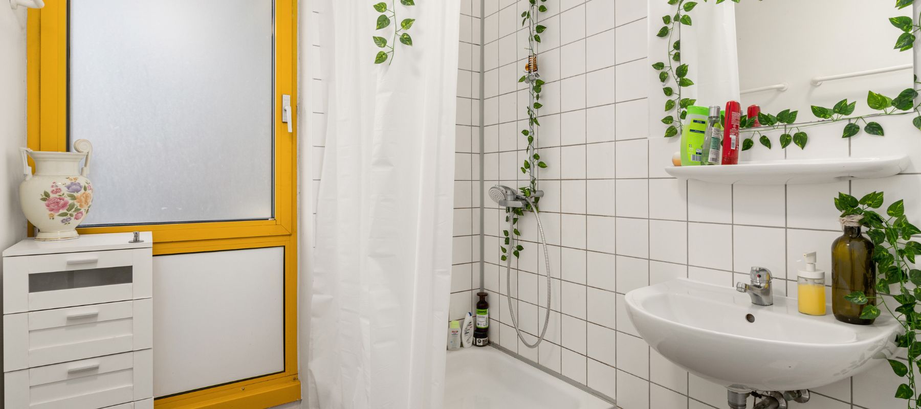 Gemeinschaftsbadezimmer für Frauen in einer WG. Zu sehen ist ein Waschbecken sowie die Dusche.