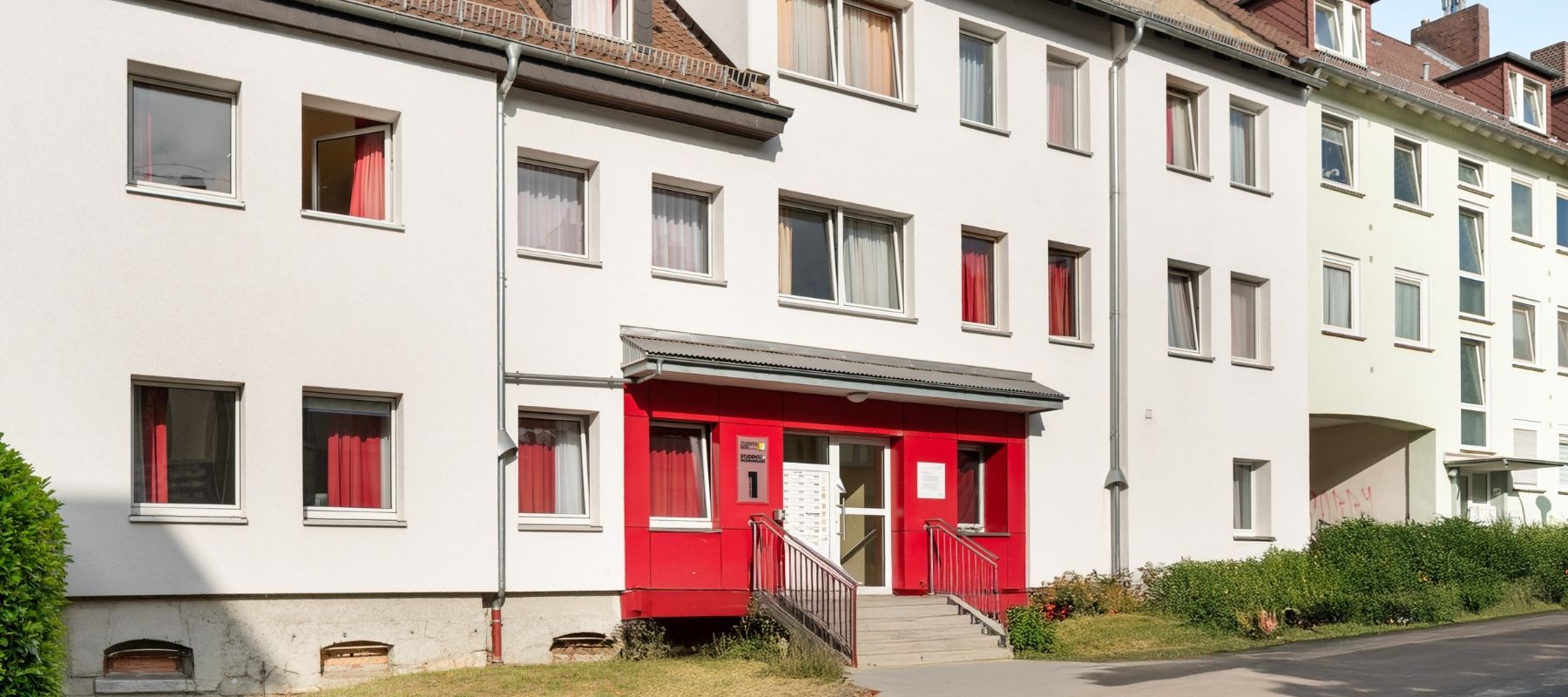 Eingang zum Wohnheim. Um den Hauseingang ist die Wand rot gestrichen.