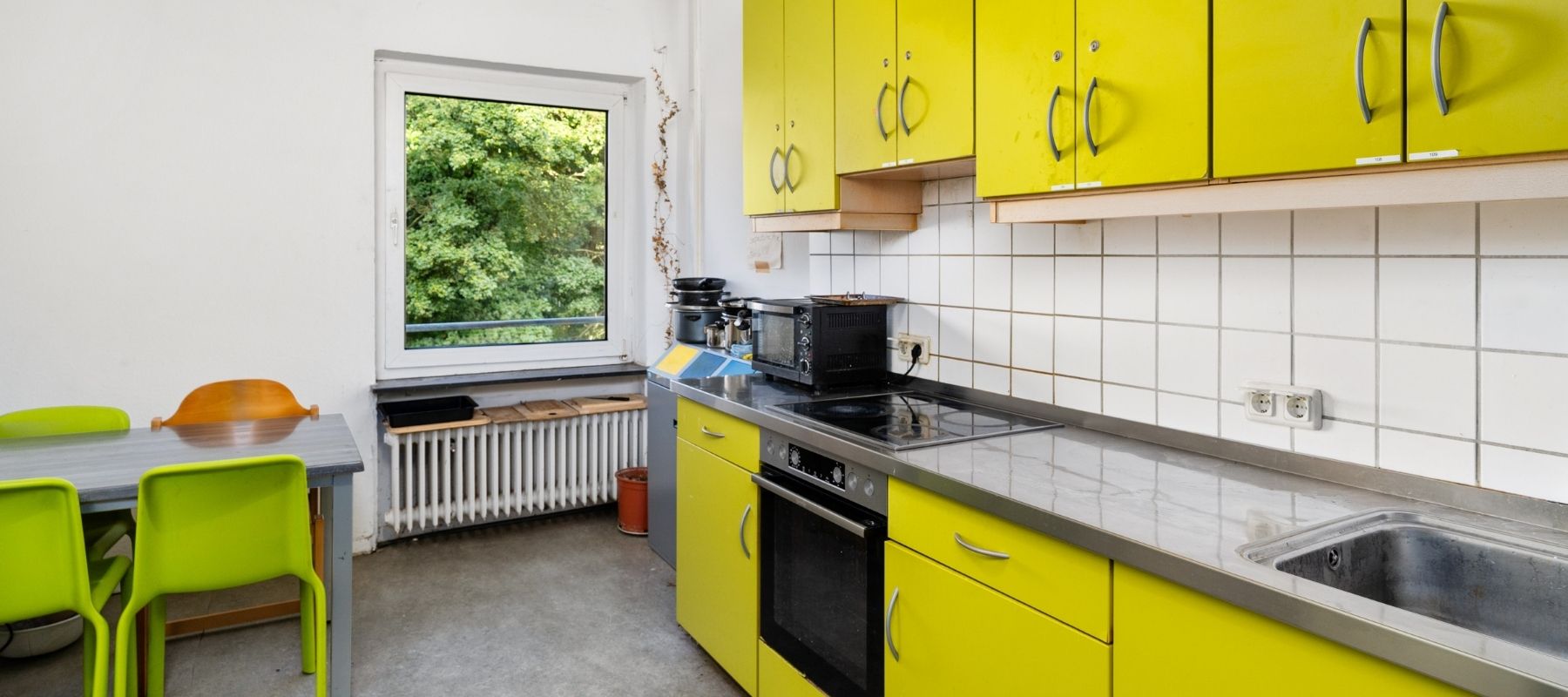 WG-Küche mit einer modernen Küchenzeile, einem Küchentisch und Stühlen.