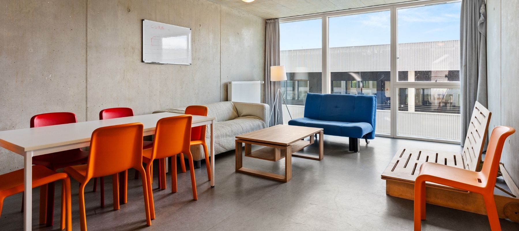 Kleiner Gemeinschaftsraum des Max Kade Hauses mit drei Sofas, Tischen und Stühlen.
