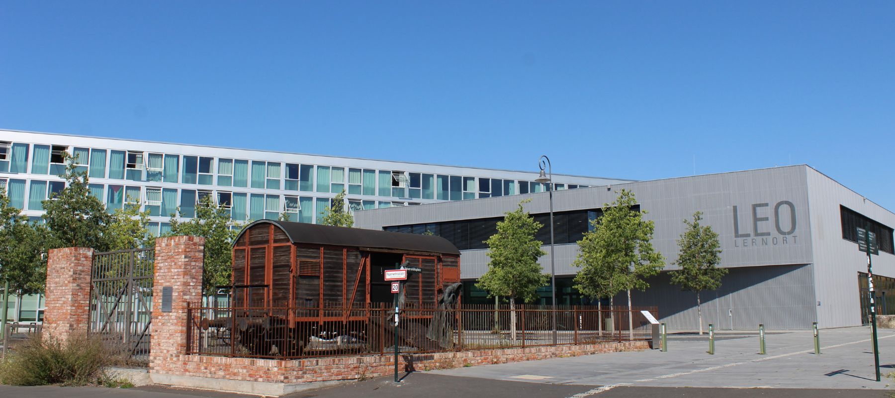 Der Blick vom Campus auf das Max Kade Haus. Im Vordergrund das Mahnmahl "Die Rampe", dahinter der LEO Lernort der Uni sowie das Wohnheim.