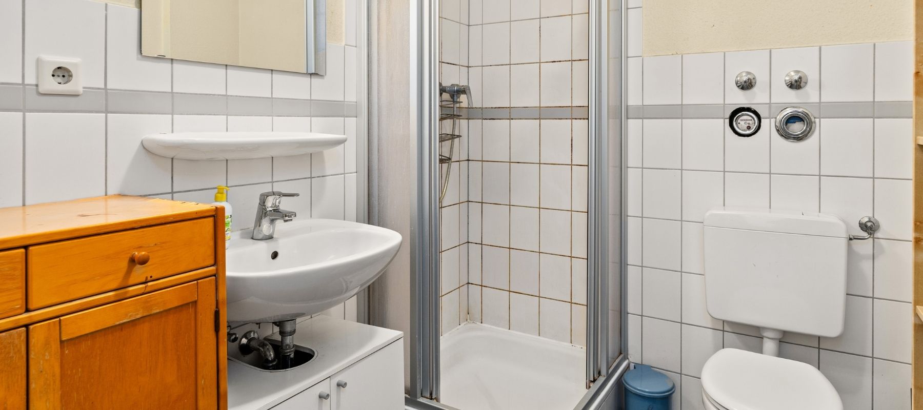 Badezimmer einer WG in der Naumburger Straße 13. Zu sehen sind Dusche, Toilette, Waschbecken und ein Schränkchen.