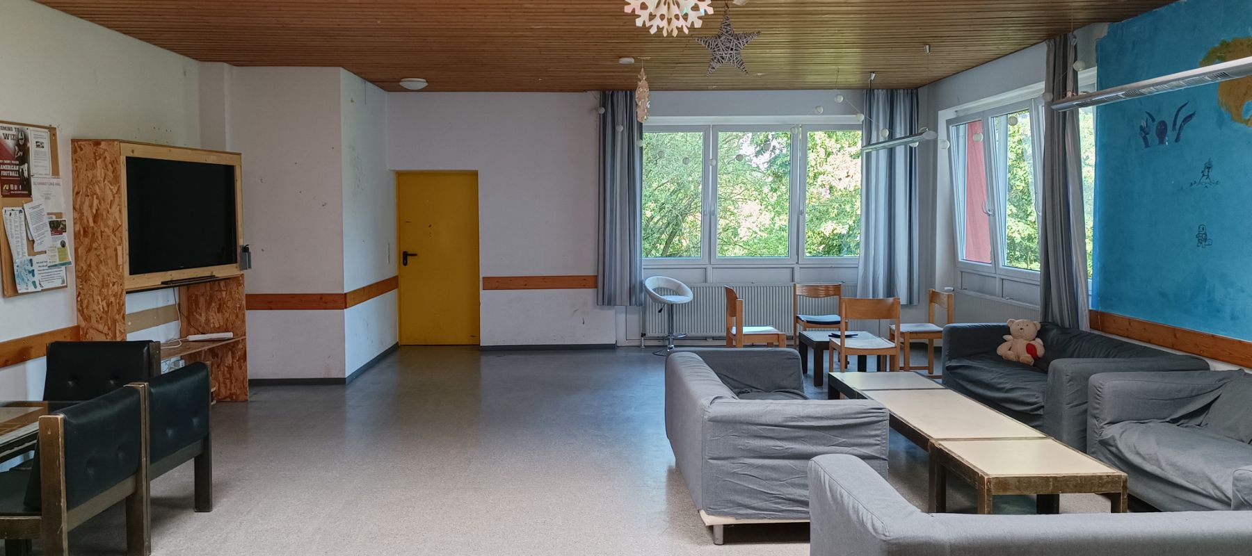 Gemeinschaftsraum im Wohnheim mit Sofas und Fernseher.