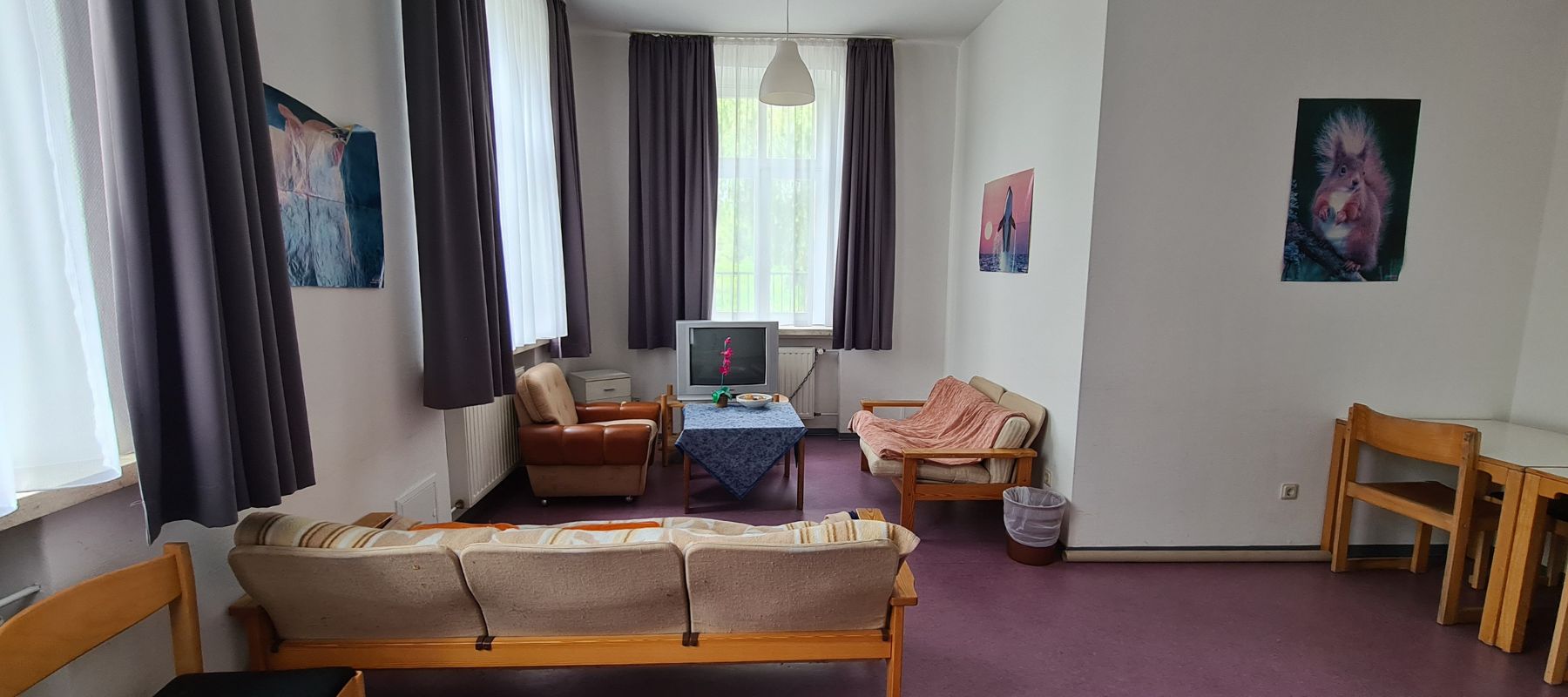 Gemeinschaftsraum im Wohnheim mit Sofas und Fernseher.